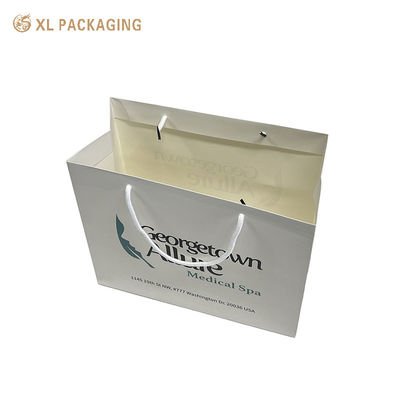 Bolsas de compras de papel impresas a medida con laminado resistente al agua y mangos de cuerda de algodón reforzado para mostrar completamente la marca