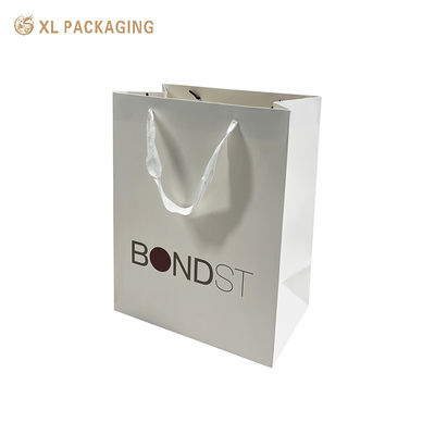 Bolsas de compras de papel de arte de 250 gramos de grosor con mangos de cinta blanca e impresión CMYK personalizada para embalajes de regalos de lujo