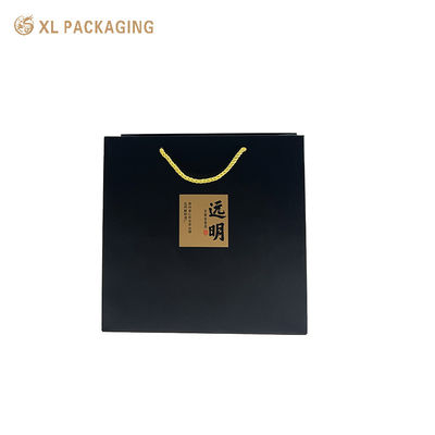 Bolso de papel negro mate con pegatinas de caligrafía Kraft y mangos de cordón dorado retorcidos para embalajes de regalos ecológicos