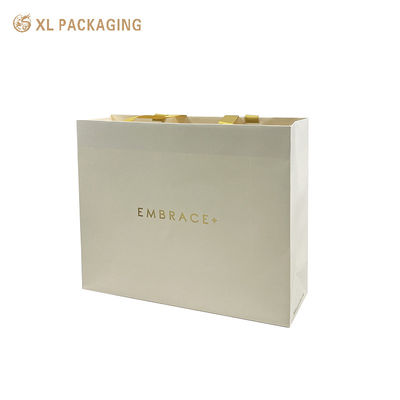Bolsa de regalo de papel estampada con lámina dorada personalizada de primera calidad con asas de cinta satinada y parte superior doblada reforzada